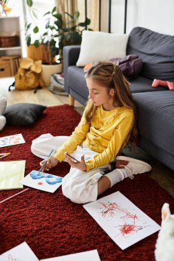 Gen alfa kızı yerde oturur, resim yapar ve öğleden sonra evde yaratıcı vaktinin tadını çıkarır..