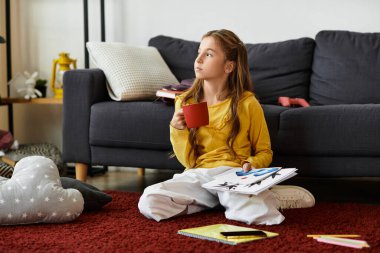 Sıcak bir oturma odasında, alfa bir kız halının üzerinde bir içkiyle rahatlar.