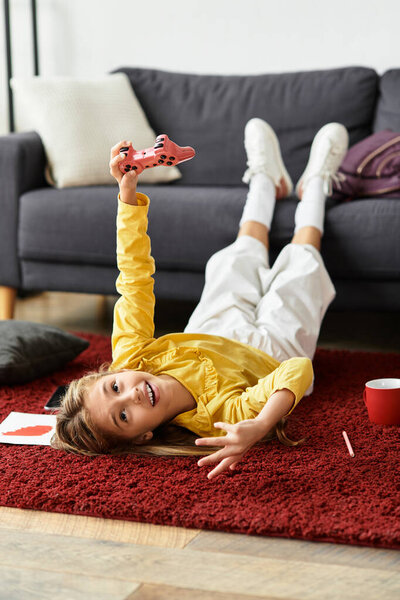 Веселая девушка расслабляется дома, играя в видеоигры на уютном ковре.