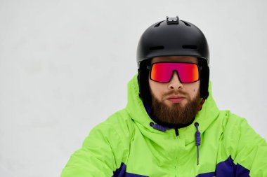 Kar yamacında kar kayağı yapan sakallı bir adam kış sporlarının heyecanını yaşıyor..