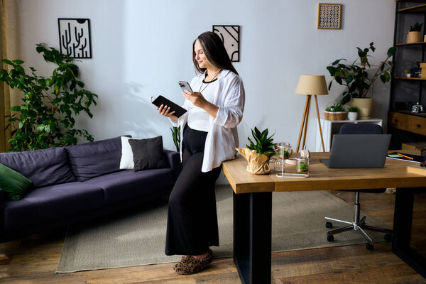 Женщина с синдромом Варденбурга удаленно работает в своем уютном домашнем офисе среди растений.