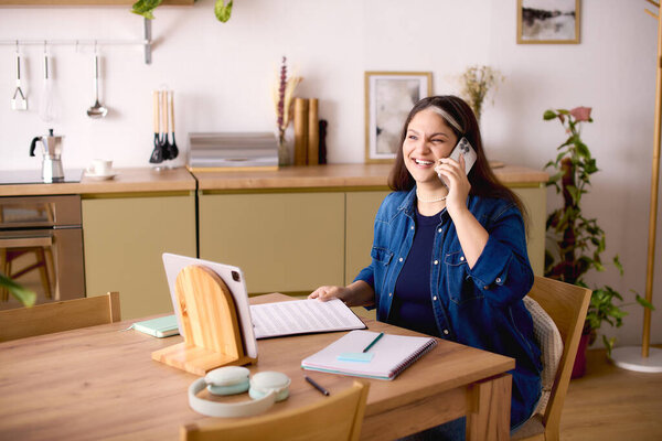 В ярком домашнем офисе женщина с синдромом Варденбурга счастливо работает на вызове.