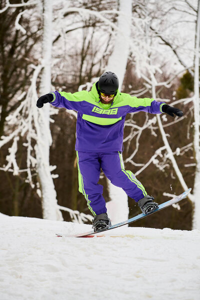 Бородатый человек выполняет стильный трюк во время сноуборда на свежем, снежном склоне.
