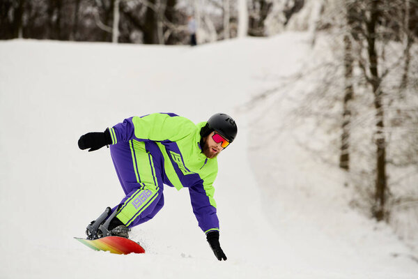 A bearded man skillfully snowboards down a snowy slope, showcasing his winter athleticism.