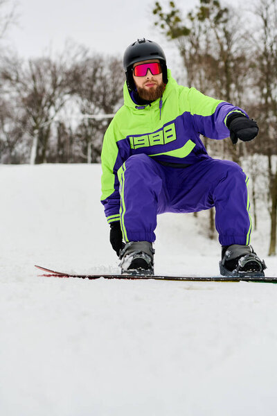 Бородач умело перемещается по снежному склону на сноуборде, демонстрируя свой атлетизм..