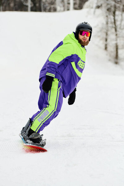 A bearded man snowboards down a snowy slope, showcasing cool moves in bright winter attire.