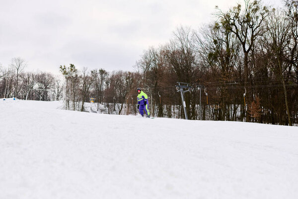 Бородатый человек изящно сноуборд вниз по снежному склону, обнимая зимний холод.