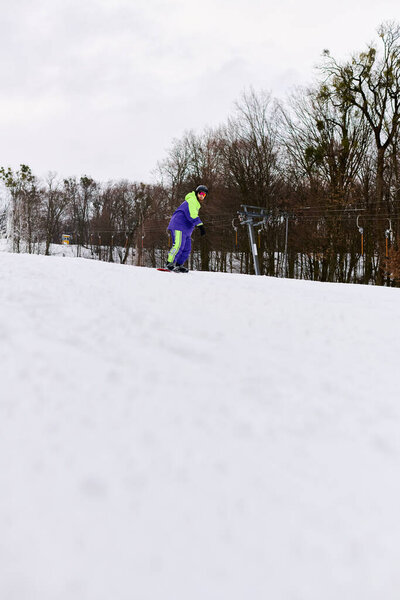 Бородач вырезает свежий порошок на снежном склоне, увлекаясь зимними видами спорта..