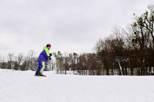 A bearded man carves through fresh snow, embracing winter thrill and joy in the mountains.