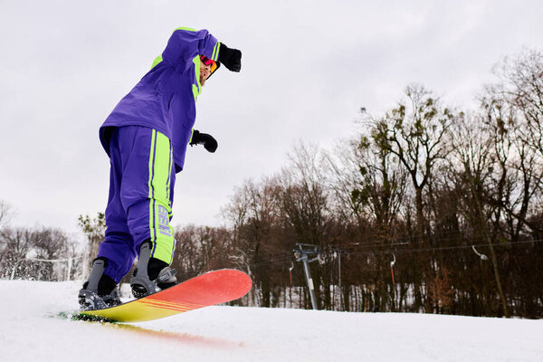 Опытный человек с бородой любит кататься на сноуборде по снежному склону в окружении зимней природы.