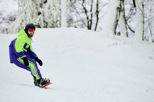 A skilled snowboarder navigates a snowy slope with excitement and style on a winter day.
