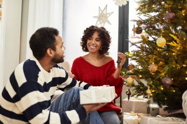 Mutlu bir çift, Noel 'i neşeyle dolu güzel dekore edilmiş bir salonda birlikte kutlar..
