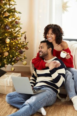 Mutlu çift, Noel 'i birlikte kutluyor. Süslü ağacın yanında, kahkahalarını ve sıcaklığını paylaşıyorlar..