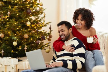 Mutlu bir çift Noel 'i birlikte geçirir, güzel süslenmiş ağaçlarının yanında kahkahalarını paylaşırlar..