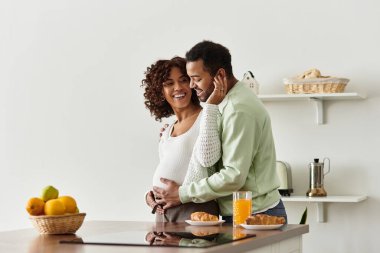 Anne babalar aşklarını ve yeni gelişlerini kutlamak için neşeli bir mutfak anının tadını çıkarıyorlar..