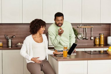 Neşeli bir çift, yeni gelişlerine hazırlanırken mutfaklarında birlikte vakit geçirirler..