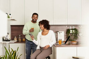 Mutlu bir Afro-Amerikan çifti, yaklaşan bebeklerini kutlamak için evde vakit geçirir..