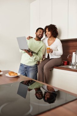 Bir çift şık mutfaklarında birlikte vakit geçirirken kahkaha ve atıştırmalıkları paylaşıyor..