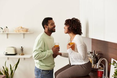 Mutlu bir çift, şık evlerinde şefkatli anlarını paylaşırken içkiden zevk alır..