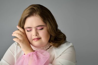 Down sendromlu genç bir kadın yavaşça gülümser, gözleri kapalı, mutluluk ve mutluluk saçar..