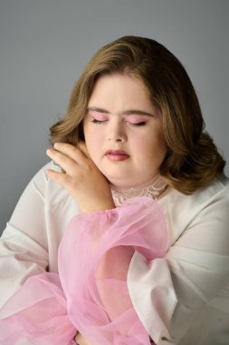 Down sendromlu neşeli genç bir kadın zarif bir şekilde poz verir, huzurlu bir ortamda mutluluk saçar..