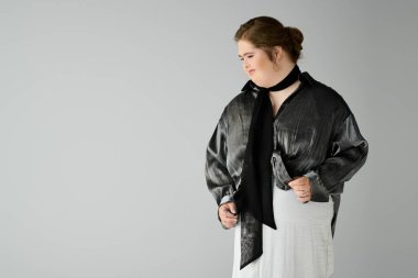 Down sendromlu genç bir kadın çekiciliğini gülümseyerek ve şık bir kıyafet giyerek gösteriyor..