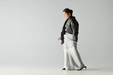 Down sendromlu genç bir kadın sakin bir ortamda şık bir kıyafetle rahatça yürüyor..