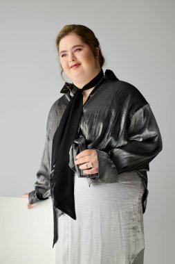 Down sendromlu genç bir kadın, parlak bir stüdyoda poz verirken mutluluk ve güven gösteriyor..