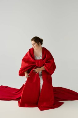 Down sendromlu genç bir kadın lüks kırmızı elbisesiyle, sıcaklık ve kendine güvenle ışıldıyor..