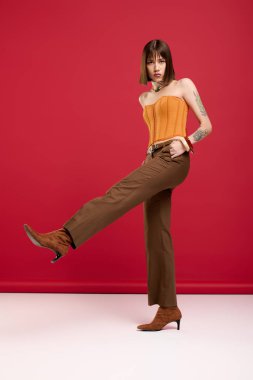 Tarz sahibi genç bir kadın modaya uygun bir şekilde poz veriyor ve kendine has moda anlayışını gösteriyor..