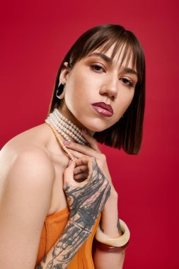 Moda kıyafetleri içinde genç ve güzel bir kadın, kendine güvenen pozlar verirken dövmelerini sergiliyor..