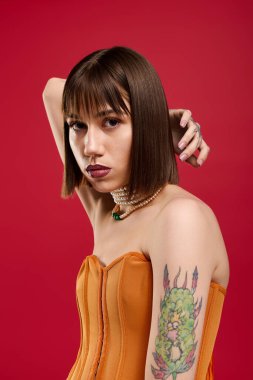 Renkli kıyafetli çekici genç kadın cesur bir arkaplan karşısında eşsiz bir stil sergiliyor..