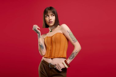 Genç bir kadın stili ile gösteriş yapıyor dövmeleri ve şık kıyafetleri ile.