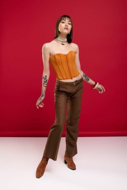 Genç ve güzel bir kadın kendine güvenerek şık bir şekilde poz verir. Yaratıcılık ve cazibe yayar..