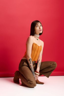 Güzel, genç bir kadın zarif bir şekilde poz veriyor, hareketli bir atmosferde moda kıyafetinin altını çiziyor..