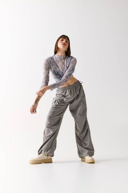 Genç ve güzel bir kadın, kendine güvenerek şık bir şekilde poz verir. Tarz ve zarafet duygusunu yakalar..