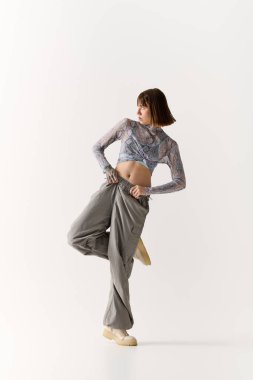 İleri moda genç kadın şık bir şekilde poz veriyor, özgüven ve zarafeti somutlaştırıyor..