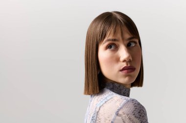 Çekici genç kadın kendine güvenen minimalist bir ortamda eşsiz tarzını sergiliyor..