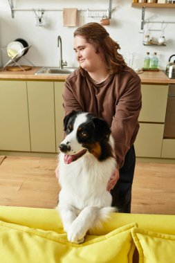 Down sendromlu genç bir kadın evine hoş geldin demek için köpeğiyle arkadaşlık ediyor..