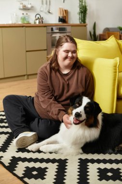 Down sendromlu genç bir kadının evcil köpeğiyle mutlu mesut etkileşime girdiği parlak yaşam alanı..