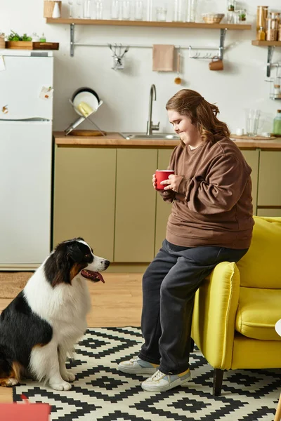 Rahat bir evde, Down sendromlu genç bir kadın köpeğiyle keyifli anlar yaşıyor..