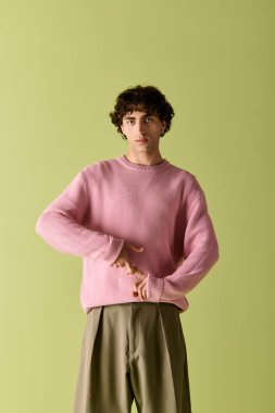 Şık giyinmiş yakışıklı bir adam canlı bir arkaplana karşı modaya uygun bir pastel elbise sergiliyor..