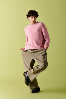 Moda kıyafetleri içinde kendine güvenen bir adam zarif bir şekilde stüdyoda poz verir..