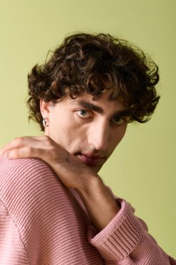 Şık giyinmiş yakışıklı bir adam büyüleyici bir pozla kendi tarzını sergiliyor..