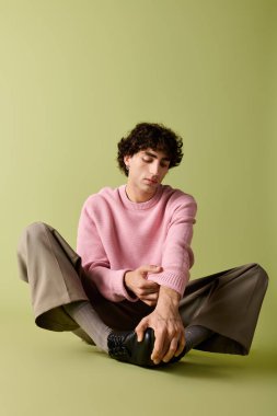 Şık bir beyefendi yerde oturmuş, kendine güveni tam, modaya uygun bir yerde..