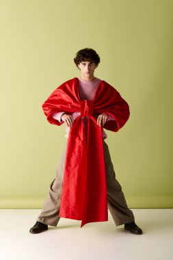 Yakışıklı bir adam kendine güvenerek çarpıcı bir renk ve modern stil elbisesi sergiliyor..