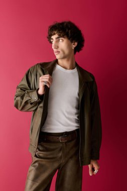 Yakışıklı adam zarif kıyafetler sergiliyor, modern moda anlayışı ve çekiciliği somutlaştırıyor..