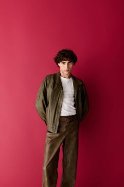 Yakışıklı bir adam kendine güvenerek şık bir elbisenin içinde duruyor, moda ve karizmayı ön plana çıkarıyor..