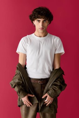 Yakışıklı adam rahat bir tavır sergilerken modaya uygun giyinerek rahatça poz veriyor..