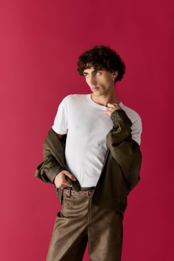 Şık bir adam, kendine güveni tam pembe bir duvara karşı duruyor. Yeteneğini sergiliyor..